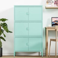 a blue cabinet sitting next to a potted plant