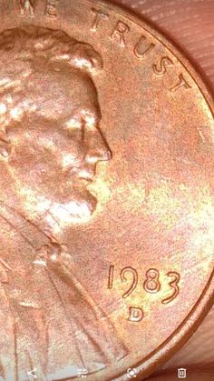 a close up of a penny on a person's hand