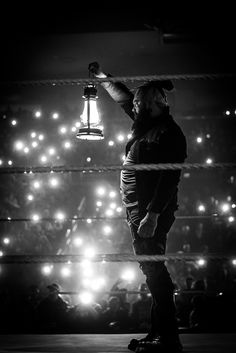 a man standing on top of a skateboard in front of a crowd at night