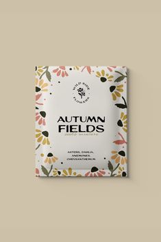 the front cover of an autumn field book with flowers and leaves in black, orange, yellow