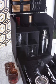 an open black box with bottles and glasses in it