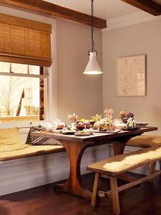 a dining room table and bench in front of a window