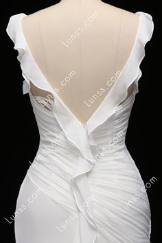 the back of a white wedding dress with ruffles