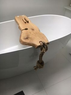 a bathtub with rope attached to it and a wooden piece of wood on the side