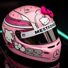 a pink helmet with a hello kitty on it's side and a name tag