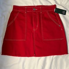 Red Denim Mini Skirt Red Spring Skirt With Pockets, Red Skirt With Pockets For Spring, Red Cotton Lined Skirt, Red Cotton Mini Denim Skirt, Red Cotton Bottoms With Frayed Hem, Red Casual Mini Skort, Trendy Red Denim Skirt For Summer, Casual Red Mini Skort, Red Casual Mini Length Skort