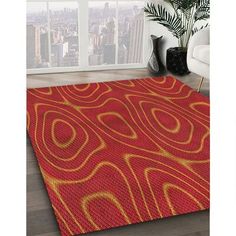 an orange and yellow area rug in front of a window with cityscape behind it