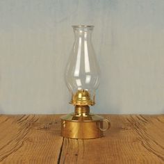 an old fashioned lamp is sitting on a wooden table