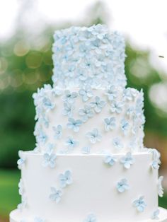 a three layer white cake with blue flowers on it