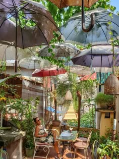 an outdoor cafe with umbrellas and plants