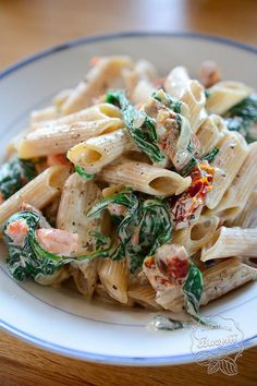 pasta with spinach, shrimp and cheese on a white plate