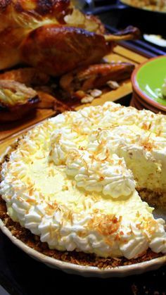 a pie sitting on top of a wooden table next to other plates and turkeys