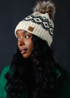 This cozy winter hat features a speckled detail and faux fur pom accent for a stylish and unique look. Fleece-lined, this hat is designed for comfort and warmth. Keep your head warm in style with this must have winter hat!  Cream and black patterned pom hat  Speckled throughout Natural faux fur pom accent Fleece lined Crown patch on the left side One size Designed in the U.S.A. Produced in China.  100% Acrylic Knitted Hats Kids, Cable Knit Hat, Fair Isle Pattern, Winter Hats For Women, Pom Pom Hat, Pom Beanie, Fur Pom Pom, Cozy Winter, Cozy Knits