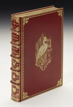 a red book with gold trimmings and a bird on the front cover is shown