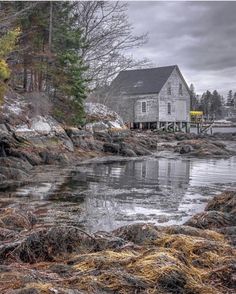 a house sitting on top of a rocky shore