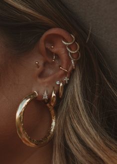 a close up of a person with ear piercings on their ears and behind the ear