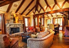 a living room filled with furniture and a fire place in the middle of a room