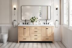 a bathroom with two sinks, a toilet and a large mirror above the vanity area