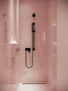 a pink tiled bathroom with a shower head and hand held shower faucet in the corner