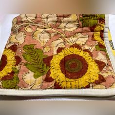 a close up of a piece of fabric on a table cloth with flowers and leaves