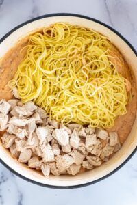 pasta and chicken in a pan on a marble counter