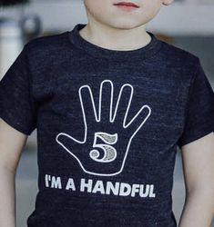 a young boy wearing a t - shirt that says i'm a handful