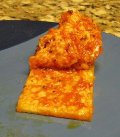 two pieces of pizza sitting on top of a blue plate next to a granite counter