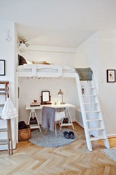 there is a loft bed with a desk and ladder in the room that has stairs to it