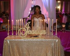 a woman standing in front of a cake with candles on it at a wedding reception