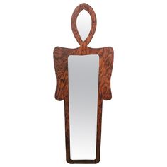 a wooden sculpture holding a mirror in it's hands