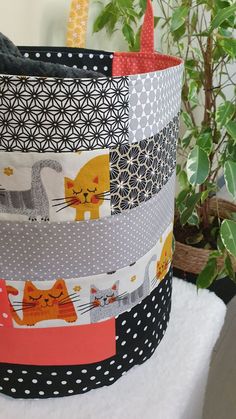 a stack of fabric covered pots sitting next to a potted plant