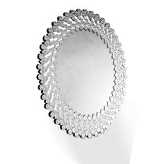 a mirror that is sitting on top of a white wall with many circles around it