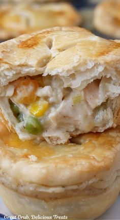 A close up photo of two mini chicken pot pies stacked on top of one another and a bite taken out of the top one.