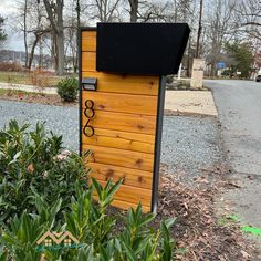 there is a mailbox with the number eighty on it in front of some bushes