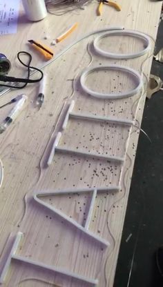 the letters are made out of plywood and wire on top of a wooden table