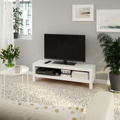 a flat screen tv sitting on top of a white entertainment center in a living room