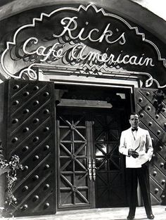 a man standing in front of a building with the words rick's cafe on it