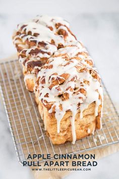 apple cinnamon pull apart bread on a cooling rack with icing drizzled over it