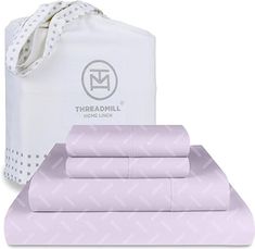 the bedding set is light purple and has a white bag on top of it