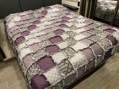 two beds with purple and white quilts in a room