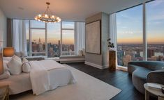 a bedroom with large windows overlooking the city