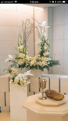 a table topped with flowers and a vase filled with white flowers