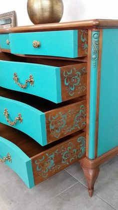 an old dresser has been painted blue and gold with intricate designs on the top drawers