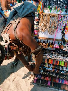 a man is selling bracelets and necklaces on the beach