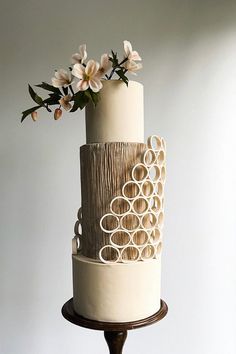 a three tiered cake decorated with circles and flowers