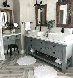 a bathroom with two sinks, mirrors and rugs on the floor in front of them