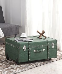 a green trunk sitting on top of a rug