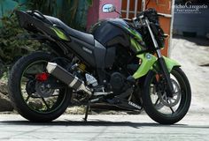 a green and black motorcycle parked in front of a building