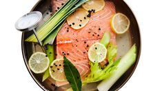 salmon, celery, and lemons on a plate with a measuring spoon