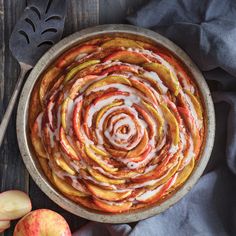 an apple pie with white icing and sliced apples